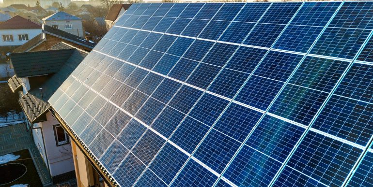 aerial-view-new-modern-two-story-house-cottage-with-blue-shiny-solar-photo-voltaic-panels-system-roof-renewable-ecological-green-energy-production-concept aerial-view-new-modern-two-story-house-cottage-with-blue-shiny-solar-photo-voltaic-panels-system-roof-renewable-ecological-green-energy-production-concept